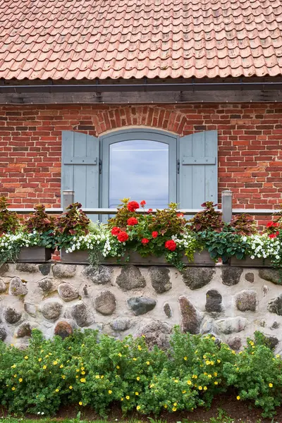 ヴィンテージの窓とガラニウムや他の花で装飾されたバルコニー — ストック写真
