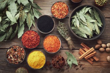 Bowls of various spices - red hot pepper, paprika, saffron, black seeds, nutmegs, cardamom, thyme, anise, gloves, curcuma, cinnamon, laurel. Different seasoning. Ayurveda remedies. Top view, flat lay. clipart