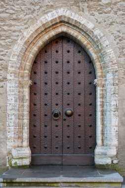 Estonya 'nın Tallinn şehrinde eski bir ortaçağ taş bina cephesinin klasik kapısı..