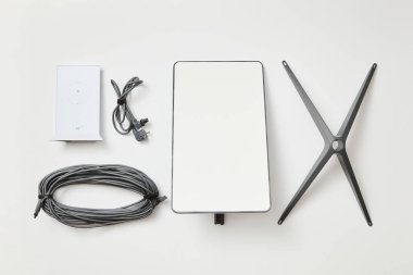 KYIV, UKRAINE - JANUARY 24, 2023: Basic Starlink kit, antenna, wi-fi router, base and cables, top view on white background.
