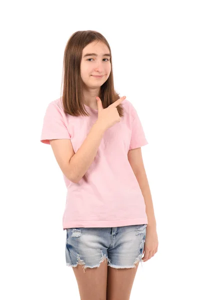 穿着粉色T恤的年轻漂亮姑娘 白色背景的斜纹棉布短裤 笑容满面 手指手画脚地朝旁边看去 脸上带着愉快而自然的表情 — 图库照片