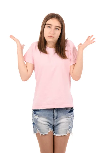 白を基調としたピンクのTシャツとデニムのショートパンツを着た若い美少女は 腕や手で持ち上げられた無慈悲で混乱した表情 疑いの概念 — ストック写真