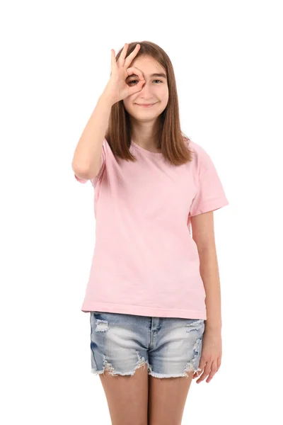穿着粉色T恤的年轻漂亮姑娘 白色背景的斜纹棉布短裤 带着微笑做手势 满脸喜色地看着手指 — 图库照片