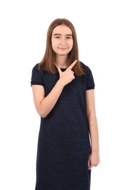Young beautiful girl in a dark blue dress on a white background, cheerful with a smile of face pointing with hand and finger up to the side with happy and natural expression on face.