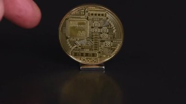 Kripto döviz kuru konsepti. Bitcoin madeni parasının siyah zemin üzerindeki ters tarafı, itildiğinde, madalyonun ön tarafına döner. Ön manzara. 4K UHD video görüntüsü 3840X2160.