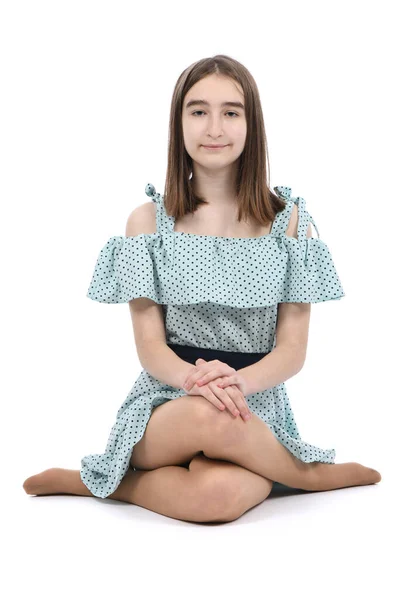 一个穿着波尔卡圆点裙的年轻漂亮的姑娘坐在地板上 被白色的背景隔开了 高分辨率照片 实地的全部深度 — 图库照片