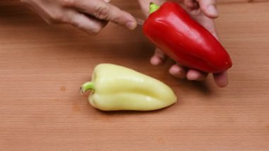 Sarı ve kırmızı dolmalık biberler tohumdan arındırılmış. Sağlıklı gıda konsepti. Sebzeleri salataya hazırlıyorum. Yan görüş. 4K UHD video görüntüsü 3840X2160.