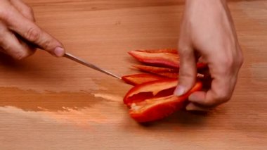 Kırmızı bir biberi bıçakla doğramak. Sağlıklı gıda konsepti. Sebzeleri salataya hazırlıyorum. 4K UHD video görüntüsü 3840X2160.