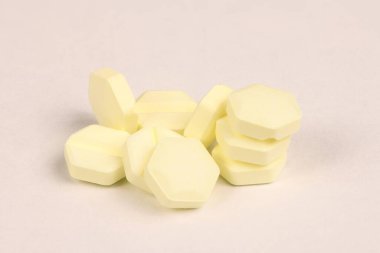 Hexagonal pills on light pink background. Extreme closeup. High resolution photo. Full depth of field.
