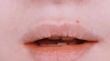 Kızın dudakları zaman ayarlı. Dudaklara yakın çekim. Çocuk eğlencesi, dudakların hareketi bir atın burnuna benzer. Yan görüş. 4K UHD video görüntüsü 3840X2160.