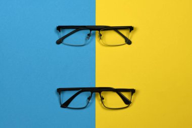 Mavi ve sarı arka planda izole edilmiş okuma gözlüğü. Kadın ve erkek için moda gözlükleri. Yüksek çözünürlüklü. Tam alan derinliği.