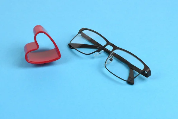 看侧面有心脏的眼镜 戴蓝色背景隔膜眼镜方便的概念 高分辨率照片 实地的全部深度 — 图库照片