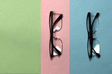 Üç renkli arka planda izole edilmiş okuma gözlüğü. Kadın ve erkek için moda gözlükleri. Yüksek çözünürlüklü. Tam alan derinliği.