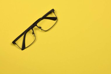 Sarı arka planda izole edilmiş okuma gözlükleri. Kadın ve erkek için moda gözlükleri. Yüksek çözünürlüklü. Tam alan derinliği.