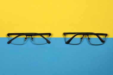Mavi ve sarı arka planda izole edilmiş okuma gözlüğü. Kadın ve erkek için moda gözlükleri. Yüksek çözünürlüklü. Tam alan derinliği.