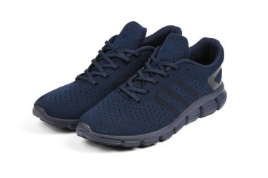 Kalın tabanlı örgü kumaştan yapılmış mavi bir spor ayakkabı, beyaz bir arka planda izole edilmiş. Spor ve sokak şık spor ayakkabılar giyer..