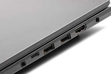 Güç portları, HDMI, USB ve ses portları olan modern dizüstü bilgisayarın ayrıntılı yan görüntüsü. Teknolojik yenilikleri ve şeffaf bağlantıları vurgulamak için mükemmel.