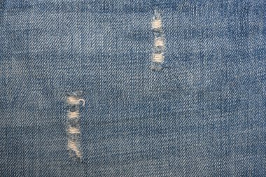 Yırtılmış mavi hippi kot pantolon kumaşı. Kot kumaş dokusunu mahvetmiş. Kapatın. Kotun yırtık arka plan dokusu. Mavi Kot kumaş kumaş malzeme yüzeyi olarak