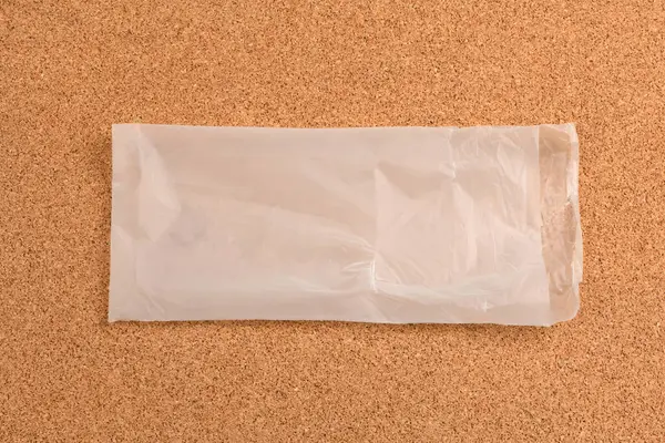 Mantar arka planda ambalaj çantası. Mantar kaplama arka planının kahverengi-sarı rengi.