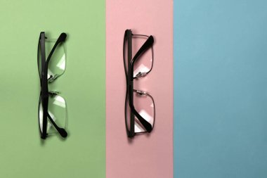 Üç renkli arka planda izole edilmiş okuma gözlüğü. Kadın ve erkek için moda gözlükleri. Yüksek çözünürlüklü. Tam alan derinliği.