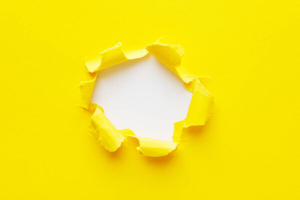 Желтая дыра в бумаге с разорванными сторонами
.