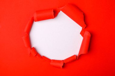 Kırmızı delik yırtık yanlarıyla gazetede.