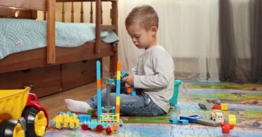 Eğitici oyuncak blokları olan komik bir çocuk. Çocuklar kreşte ya da anaokulunda oynarlar. Çocuk odasında kargaşa. Bebekler anaokulunda bir kule inşa ederler. Çocuk renkli oyuncaklarla oynuyor.