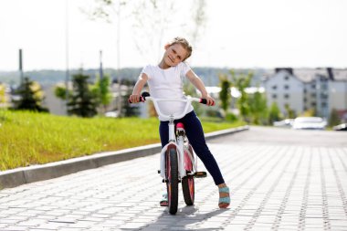 Little girl on a bicycle in summer park. cycling outdoors.