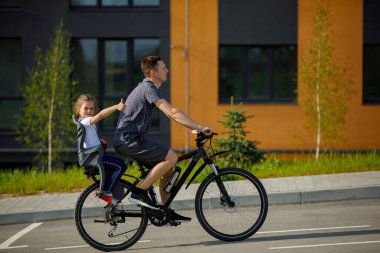 father riding bike with son in bike seat.
