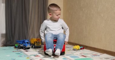 Funny baby boy with educational toy blocks. Children play at day care or preschool. Mess in kids room. Toddlers build a tower in kindergarten. Child playing with colorful toys.