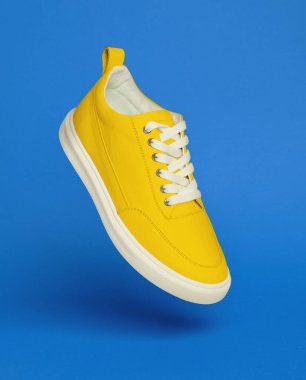 Mavi arka planda sarı spor ayakkabı