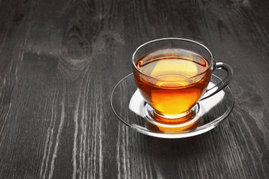 Koyu ahşap arka planda bir fincan çay.