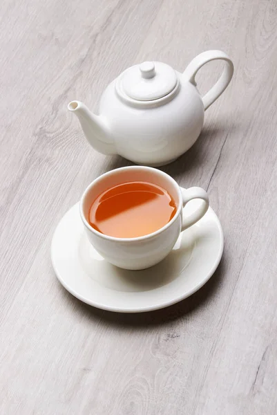 お茶とティーポットのカップ 軽い木の背景に — ストック写真