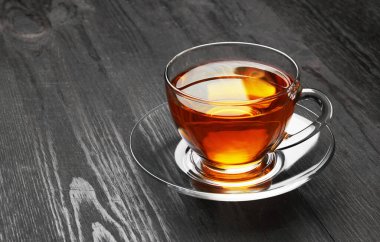 Koyu ahşap arka planda bir fincan çay.