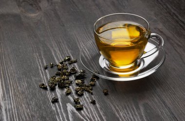 Koyu ahşap arka planda bir fincan çay.