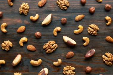 Fındık karışımı. Fındık, macadamia, badem, ceviz, fındık ezmesi, ahşap arka planda. Üst görünüm.