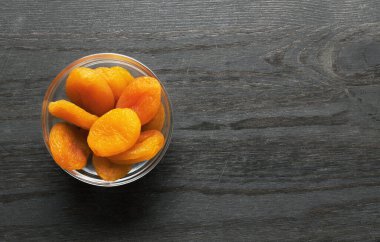 Ahşap arka planda kurumuş kayısılar.