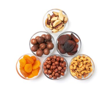 Fındık ve kurumuş kayısıları kaseye koy. Fındık, macadamia, kaju, fındık, kurutulmuş kayısı, beyaz arka planda..