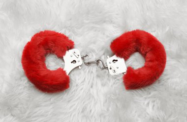 Kürk arka planında kırmızı seksi tüylü kelepçeler.