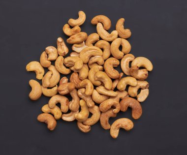 Koyu bir arka planda kızarmış kaju fıstığı.