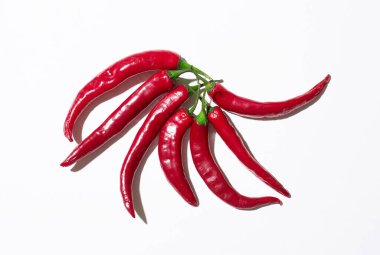 Beyaz arkaplanda birçok kırmızı biber izole edilmiş.