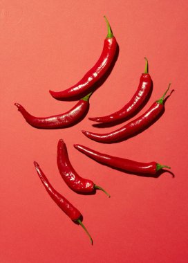 Kırmızı arka planda bir sürü kırmızı biber