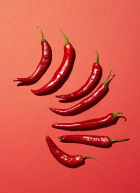 Kırmızı arka planda bir sürü kırmızı biber