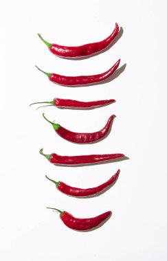 Beyaz arkaplanda birçok kırmızı biber izole edilmiş.