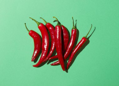 Yeşil arka planda bir sürü kırmızı biber