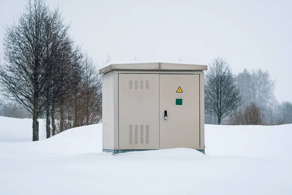 Outdoor Electric cabinet on the snow field. Electrical cabinet in the nature in the blizzard.