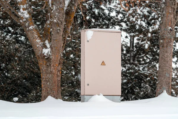 Outdoor Electric cabinet on the winter park. Electrical cabinet in the nature in the blizzard.
