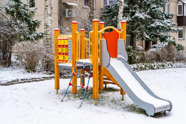Play complex playground with slides and stairs in the winter city. Organization of child development.