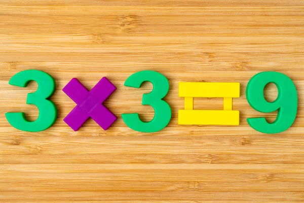 木の背景に数字磁石を使った数学の例 簡単な数学的乗法3 — ストック写真