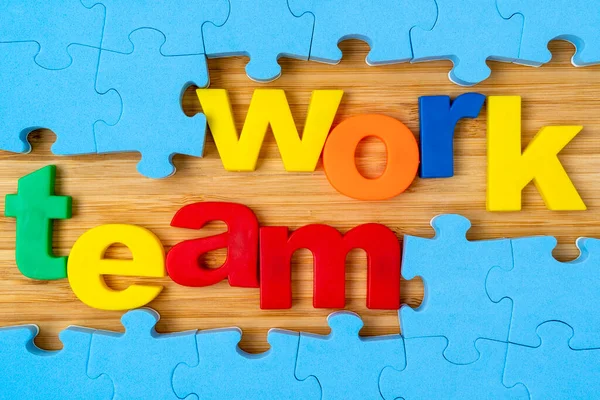 Teamwork concept business.Blue puzzle frame and color lettering TEAMWORK.